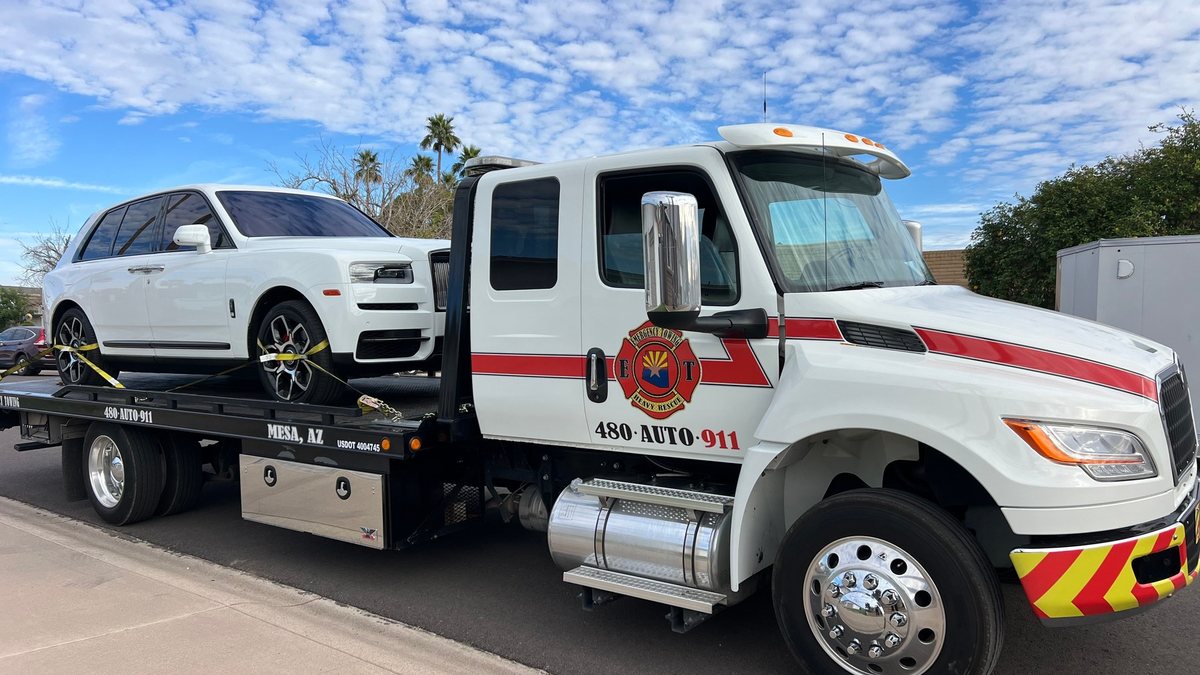 Emergency Towing flatbed transporting a white Rolls-Royce Cullinan in the East Valley