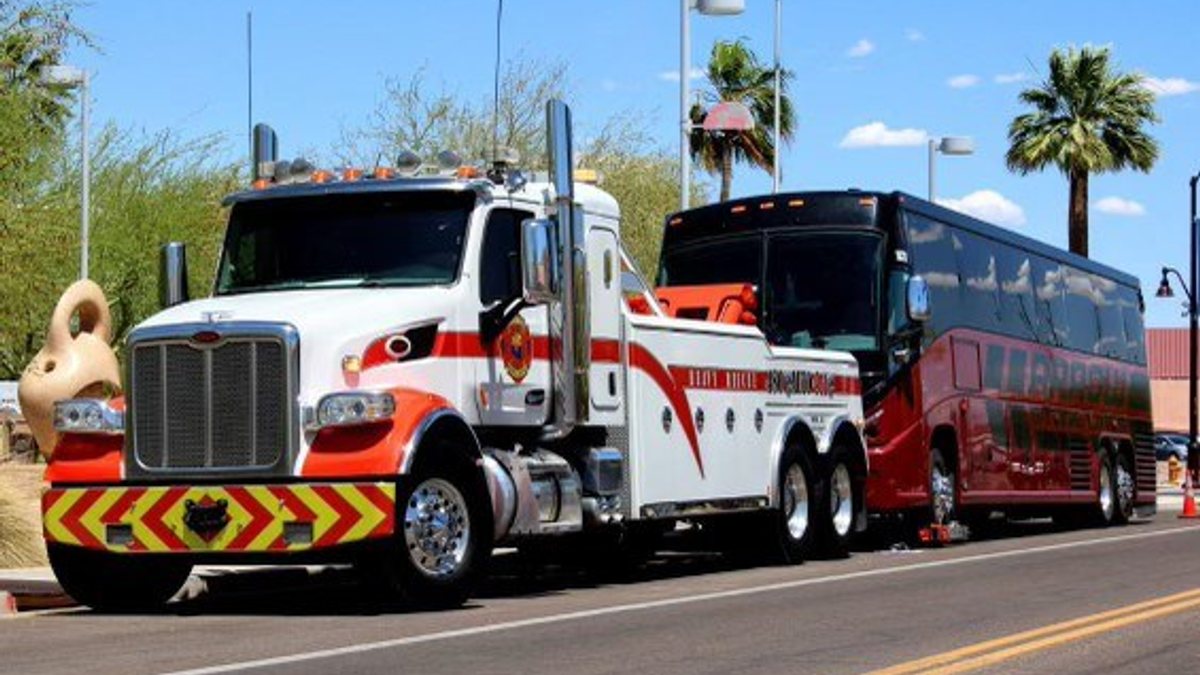 Heavy wrecker towing a motorcoach on a scenic Arizona road
